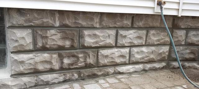 Rock-faced stone block foundation with fresh mortar joints in Omaha